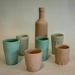 collection of 3D pastel vessels in pastel green, pink and off-white all with textural detail.