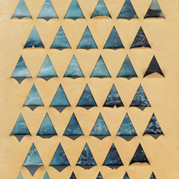 blue triangular pattern, laser cut onto wooden board.