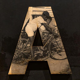 black and white photo in the letter form A, two young boys on bicycles.