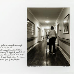 old woman walking down a hallway with walking frame, dark floorboards, cursive text on the left, black and white photograph.