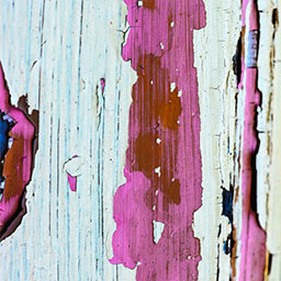 white paint on wooden surface, pink paint over the top with splashes of red.