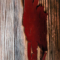 red paint peeling off rusted wooden panels.