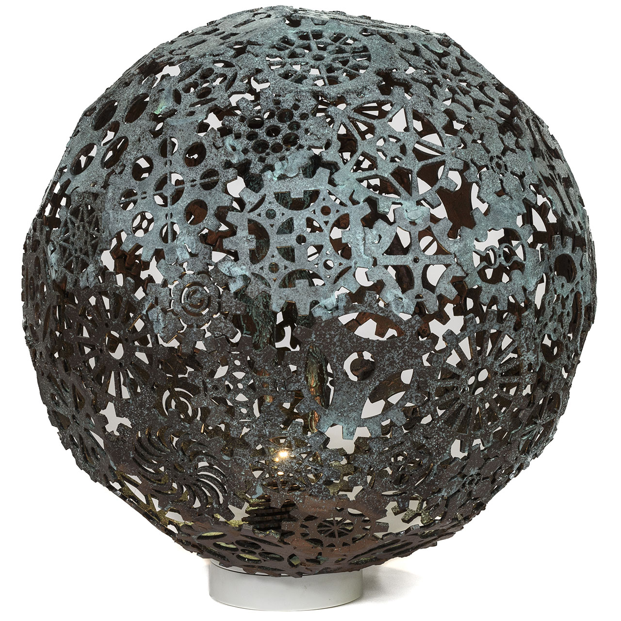 large metal sphere with patterned cut-outs sitting on stand.