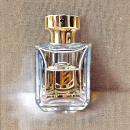 rectangular perfume bottle containing an orange liquid with gold top, thatched background