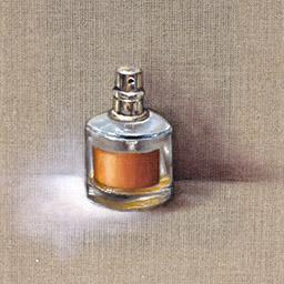perfume bottle with rounded edges and an orange label in front of a beige, thatched background