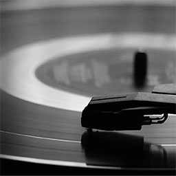 close up black and white photo of record playing 