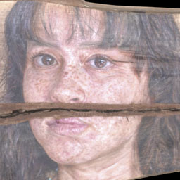 young womans face painted onto a textured slab of wood