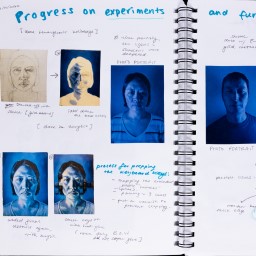 close up of open visual arts diary with progress images and negatives of the photographs