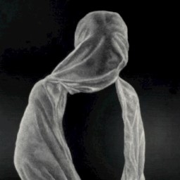 Black and white potrait of a figure with cloth draped over their head